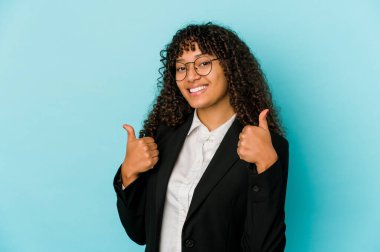 Genç Afrikalı Amerikalı Afro kadın kendini soyutlamış, iki parmağını da kaldırmış, gülümsüyor ve kendinden emin..