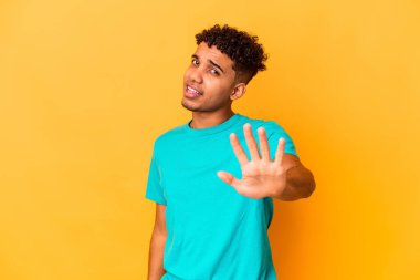 Genç Afro-Amerikalı kıvırcık adam, mor üzerine izole edilmiş, tiksinti gösteren birini reddediyor..