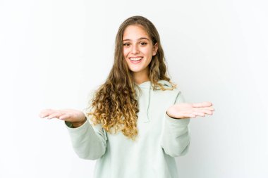 Genç beyaz kadın kollarıyla ölçek yapıyor, mutlu ve kendinden emin..