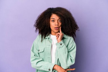 Genç Afro-Amerikalı kıvırcık kadın, mor arka planda izole edilmiş, harika bir fikri var, yaratıcılık kavramı..