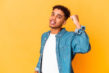 Genç Afro-Amerikan kıvırcık adamı mor bir tezahürat yapıyor ve heyecanlanıyor. Zafer konsepti.