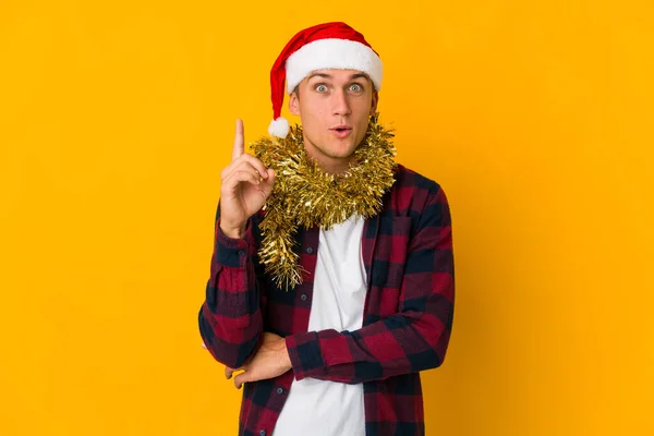 黄色の背景に孤立した存在を保持クリスマス帽子を持つ若い白人男性は いくつかの素晴らしいアイデア 創造性の概念を持っています — ストック写真
