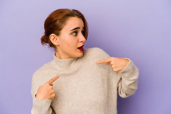 Young arab mixed race woman surprised pointing with finger, smiling broadly.