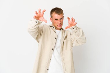 Genç, beyaz, yakışıklı bir adam pençelerini kedi taklidi yapıyor, agresif bir hareket..