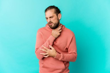 Uzun saçlı genç adam virüs ya da enfeksiyon yüzünden boğaz ağrısı çekiyor..