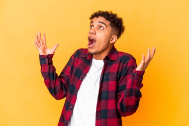 Genç Afro-Amerikan kıvırcık adamı, mor üzerine izole edilmiş, gökyüzüne haykırıyor, yukarı bakıyor, hayal kırıklığına uğramış..