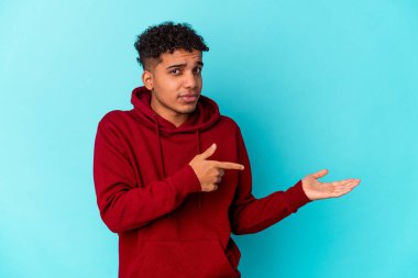 Genç Afro-Amerikalı kıvırcık adam mavi üzerine izole edilmiş..