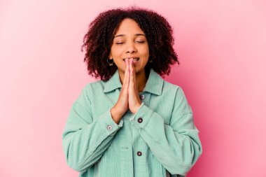 Genç Afro-Amerikan melez kadın el ele tutuşup dua ediyor, kendinden emin..