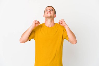 Genç beyaz yakışıklı adam zaferi, tutkuyu ve coşkuyu, mutlu ifadeyi kutluyor..