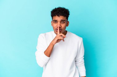 Genç Afro-Amerikalı kıvırcık adam mavi üzerine izole edilmiş bir sır saklıyor ya da sessizlik istiyor..