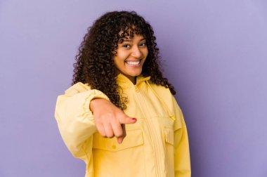 Genç Afro-Amerikan Afro kadın, yalnız başına, mutlu bir şekilde gülümsüyor..