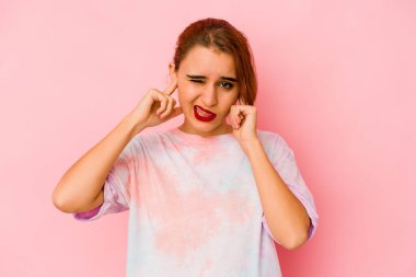 Genç Arap melez kadın kulaklarını parmaklarıyla kapatıyor, gürültülü bir ortam yüzünden stresli ve çaresiz..