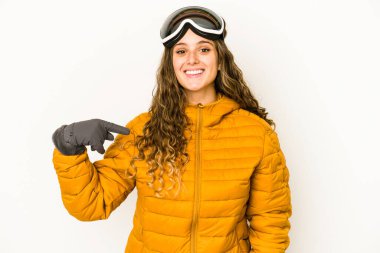 Beyaz tenli genç bir snowboardcu kadın gömlek fotokopi alanını elle işaret ediyor, gururlu ve kendinden emin.