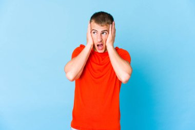 Genç, beyaz, yakışıklı, kulakları kulaklarıyla tıkayan, yüksek sesli sesler duymamaya çalışan adam..