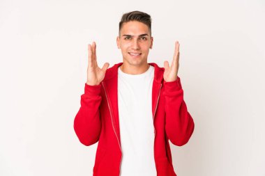 Beyaz tenli yakışıklı bir adam yalnızken kahkahalar atıyor ve elini göğsüne koyuyor..