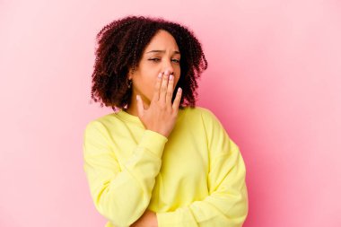 Genç Afro-Amerikan melez kadın kendini izole etmiş esniyor ve ağzını eliyle kapatan yorgun bir jest yapıyor..