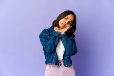 Genç melez kadın esniyor. Ağzı eliyle kapatan yorgun bir jest yapıyor..