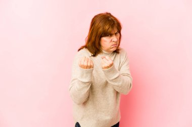 Üst düzey beyaz kadın izole edilmiş, kameraya yumruk sallıyor, agresif yüz ifadesi var..