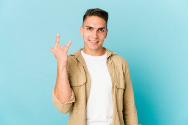 Genç, beyaz, yakışıklı bir adam izole edilmiş boynuzlarını devrim konsepti olarak gösteriyor..