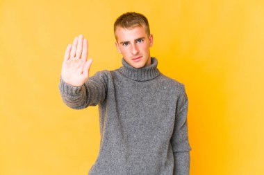 Genç, beyaz, yakışıklı bir adam elini uzatmış, dur işareti gösteriyor ve seni engelliyor..