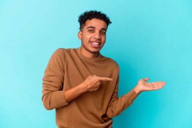 Genç Afro-Amerikalı kıvırcık adam mavi üzerine izole edilmiş..