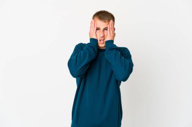 Beyaz tenli yakışıklı adam yüzünün yarısını palmiyeyle örterek eğleniyor..