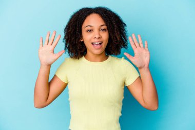 Genç Afro-Amerikan melez kadın yalnız başına 10 numarayı elleriyle gösteriyor..