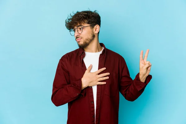 Jovem Árabe Homem Fundo Azul Fazendo Juramento Colocando Mão Peito — Fotografia de Stock