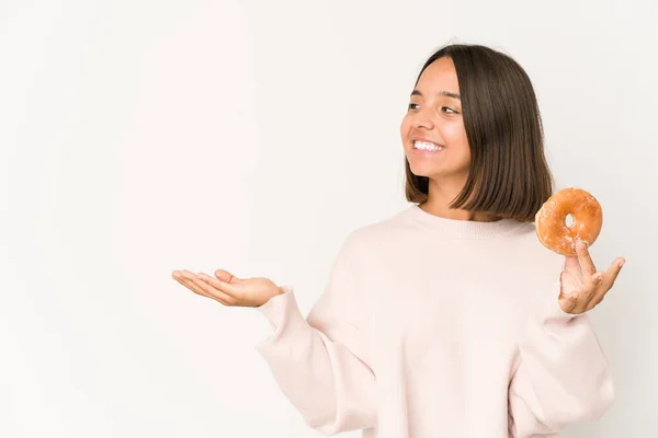 Mujer Hispana Joven Comiendo Una Rosquilla Mostrando Espacio Copia Una —  Fotos de Stock