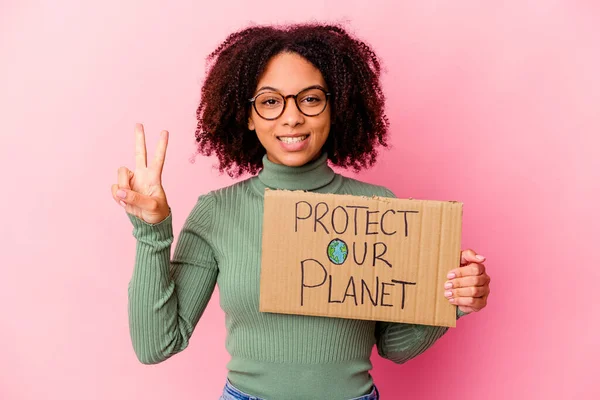 若いアフリカ系アメリカ人の混合人種の女性は指で2番目を示す私たちの惑星の段ボールを保護保持 — ストック写真