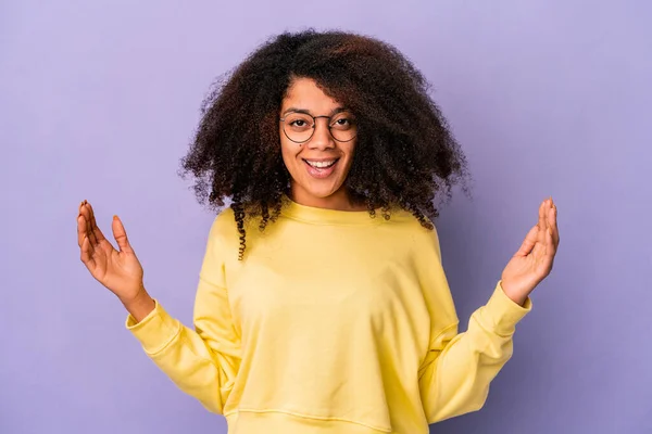 Jovem Afro Americana Encaracolado Mulher Isolada Fundo Roxo Segurando Algo — Fotografia de Stock