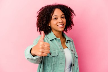 Genç Afro-Amerikan melez kadın tebessüm edip baş parmağını kaldırıyor.