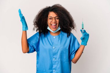 Genç Afro-Amerikan kıvırcık doktor elinde şırıngayla hoş bir sürpriz yapıyor, heyecanlı ve el kaldırıyor..