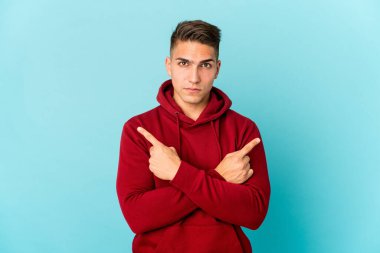 Beyaz tenli yakışıklı adam iki seçenek arasında seçim yapmaya çalışıyor..