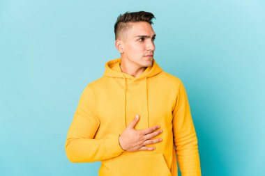 Beyaz tenli yakışıklı adam karnına dokunuyor, nazikçe gülümsüyor, yemek yiyor ve tatmin oluyor..