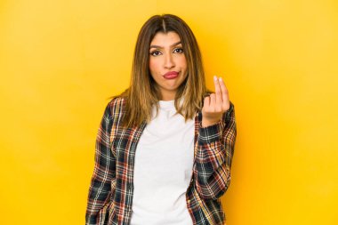 Sarı arka planda izole edilmiş genç Hintli kadın parası olmadığını gösteriyor..