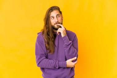 Uzun saçlı genç adam rahatlamış görünüyor. Bir şeyin fotokopi odasına baktığını düşünüyor..