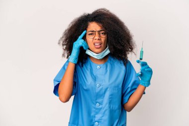 Genç Afro-Amerikan kıvırcık saçlı kadın elinde şırıngayla işaret parmağıyla hayal kırıklığı jesti gösteriyor..