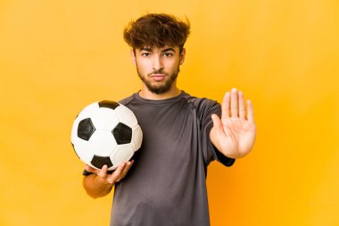 Genç futbolcu Hintli adam elini uzatıp dur işareti göstererek seni engelliyor..