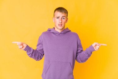 Kafkasyalı yakışıklı adam farklı kopyaları gösteriyor, birini seçiyor, parmaklarıyla gösteriyor..