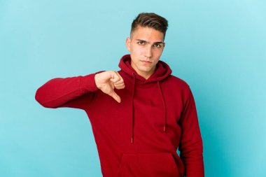 Kafkasyalı yakışıklı adam kendini izole edip baş parmağını aşağı gösteriyor. Hayal kırıklığı konsepti..