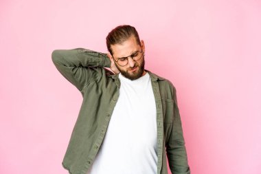 Uzun saçlı genç adam sabit yaşam tarzından dolayı boyun ağrısı çekiyor gibi görünüyor..