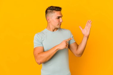 Genç, yakışıklı, beyaz bir adam izole edilmiş, tebessüm eden beş numarayı parmaklarıyla gösteriyor..