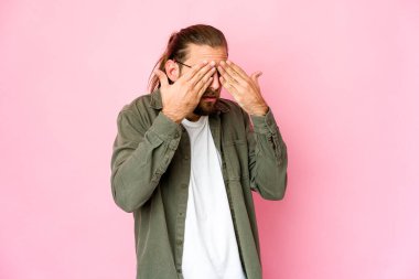 Uzun saçlı genç adam korkuyla gözlerini kapatıyor..