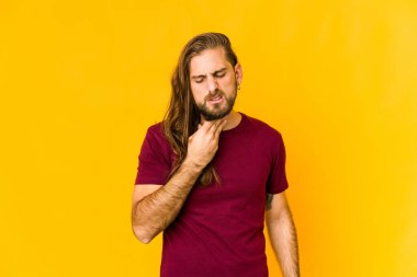 Uzun saçlı genç adam virüs ya da enfeksiyon yüzünden boğaz ağrısı çekiyor..