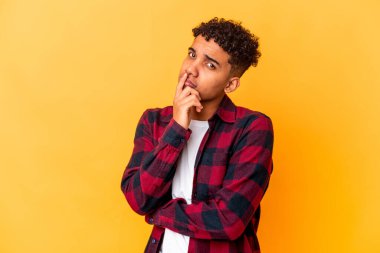 Genç Afro-Amerikalı kıvırcık adam mor mutsuz bir şekilde izole edilmiş iğneleyici bir ifadeyle kameraya bakıyor..