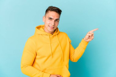 Genç beyaz tenli yakışıklı izole edilmiş, işaret parmağıyla işaret ederek gülümsüyor..