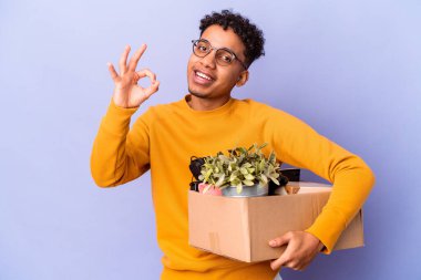 Genç Afro-Amerikalı kıvırcık adam yeni evine taşınıyor neşeli ve kendinden emin bir şekilde..