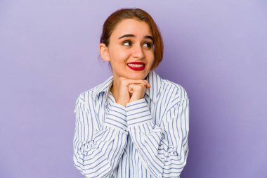 Genç Arap melez kadın ellerini çenesinin altında tutuyor, mutlu bir şekilde yan tarafa bakıyor..