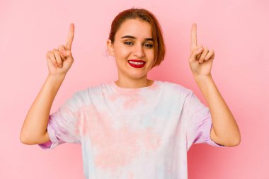 Genç Arap melez kadın iki elini de havaya kaldırarak boş bir alan gösteriyor..